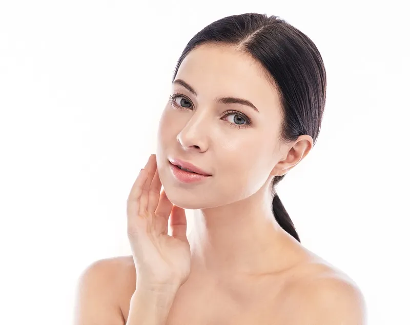 Woman with clear skin touching her cheek after acne and scar treatment